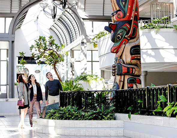 A team of professionals admires indigenous art at the Victoria Conference Centre